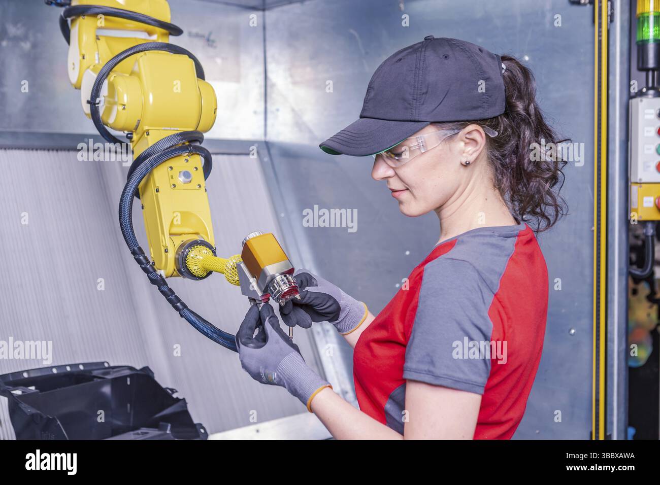 A young female technician while machine constructing in a manufacturing plant Stock Photo