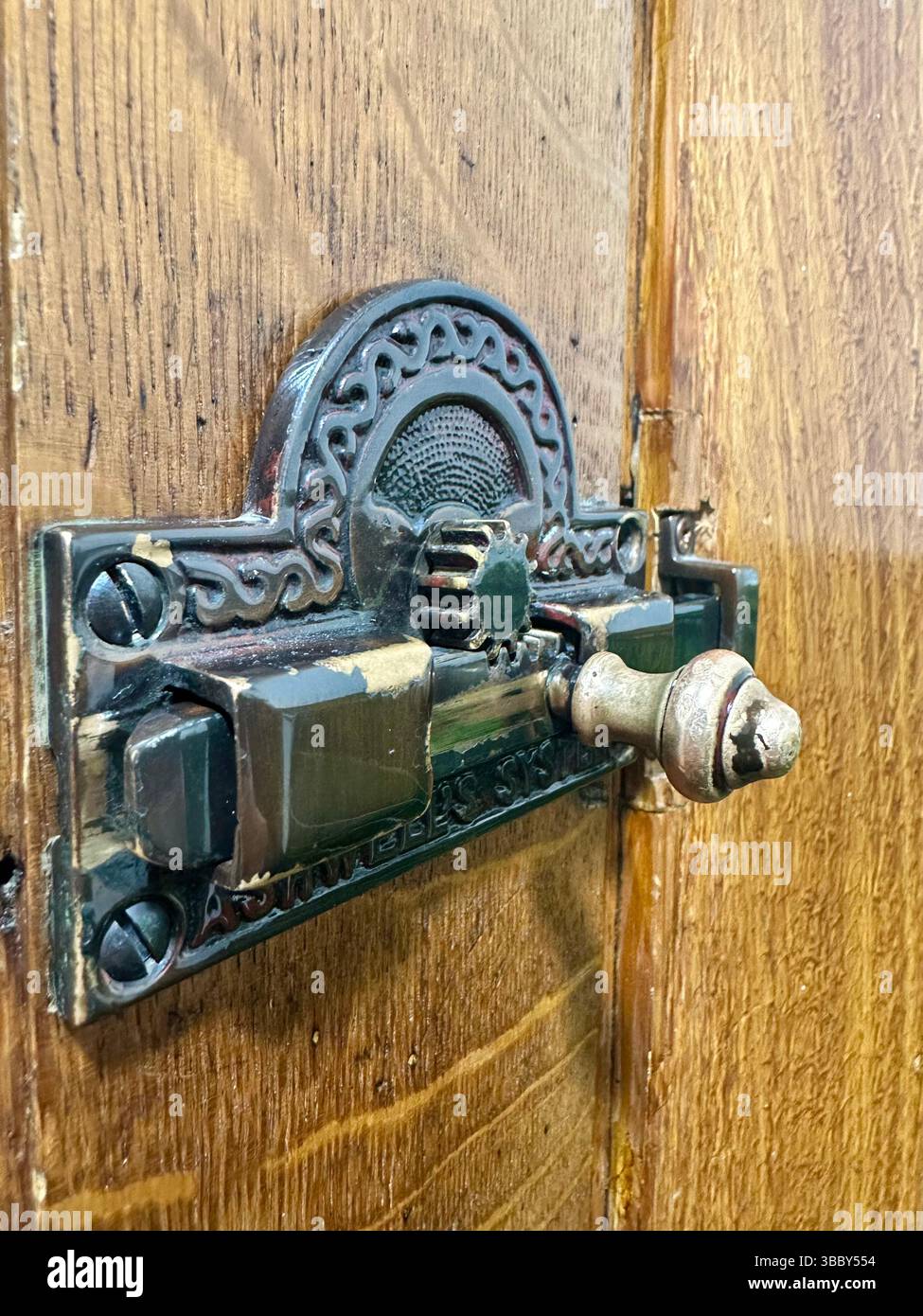 Vintage metal lock on a varnished wooden toilet door inside Liverpool Central Library. Editorial image, 17 May 2025. - Smartphone Captured Stock Image