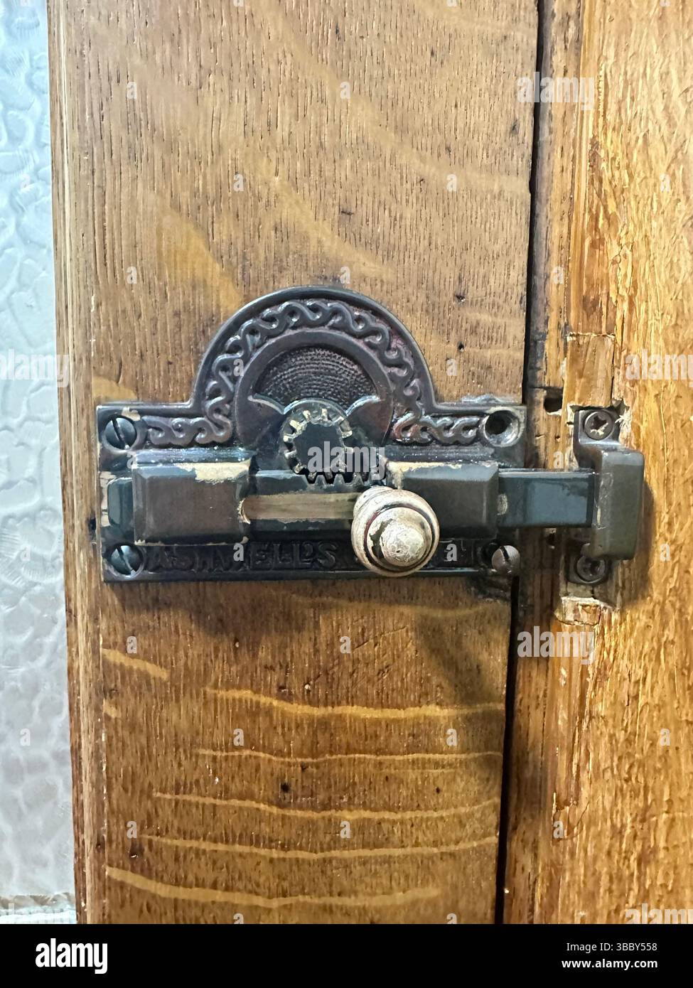 Vintage metal lock on a varnished wooden toilet door inside Liverpool Central Library. Editorial image, 17 May 2025. - Smartphone Captured Stock Image