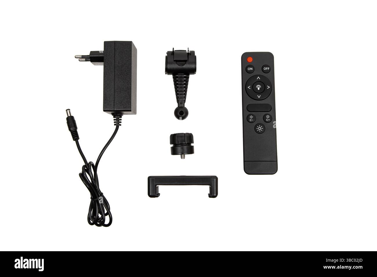 Set of lamp accessories including power adapter, remote, and mounting parts on white background. Stock Photo
