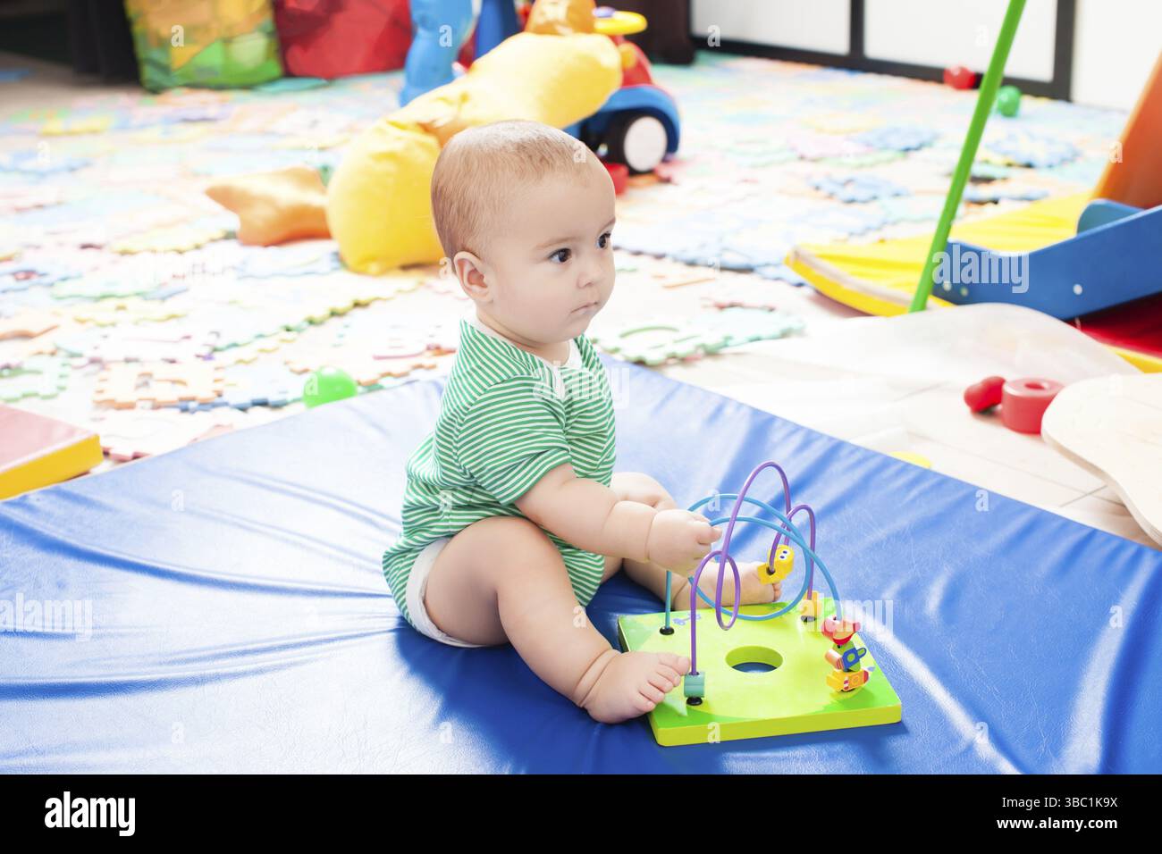 Boy is playing with labyrinth for fine motor skills in the nursery ...