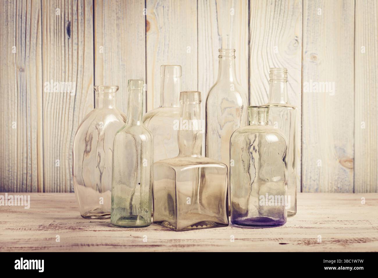 Collection of empty vintage glass bottle on a wooden background Stock Photo