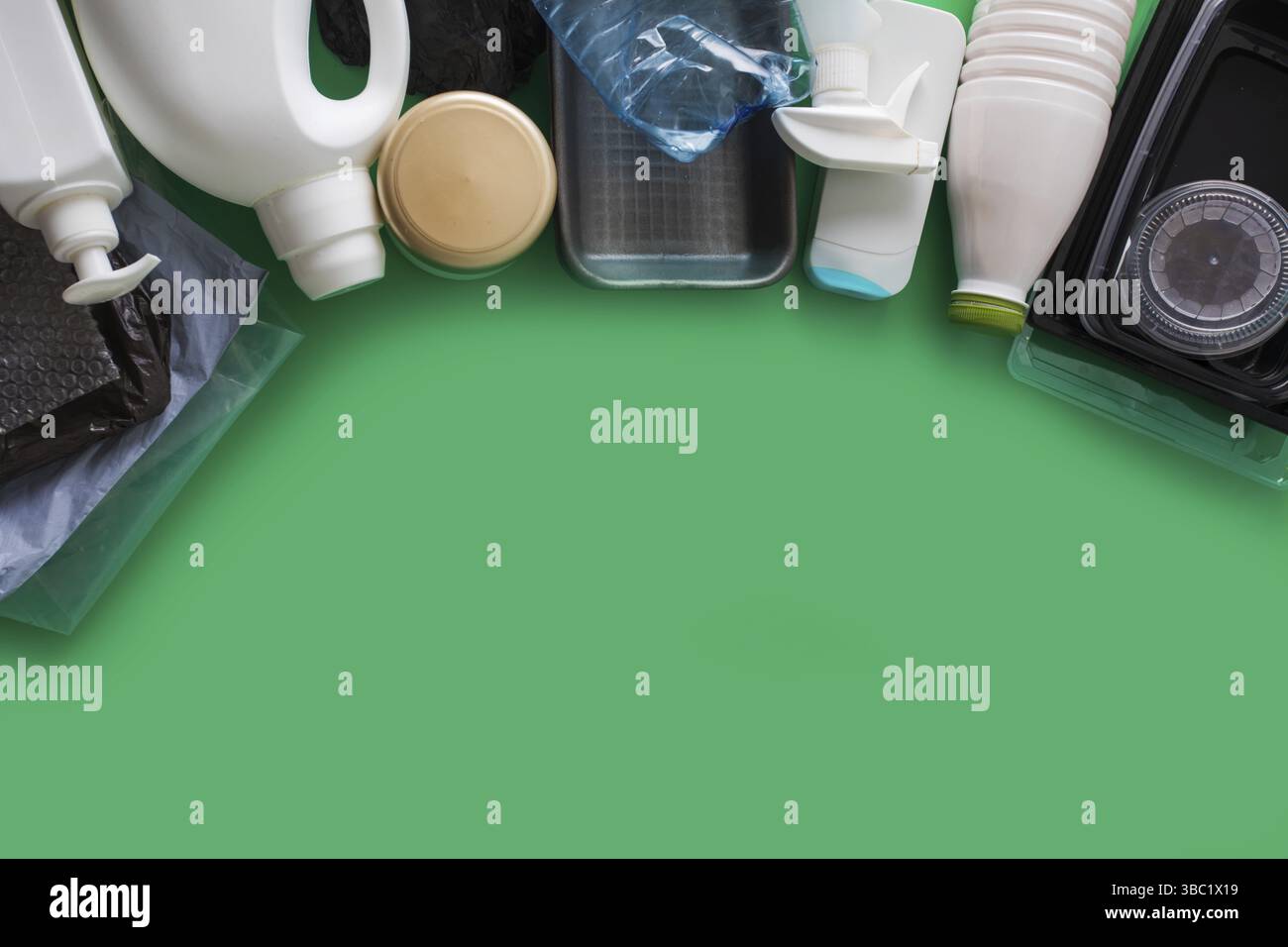 Processing plastic concept. Plastic containers on the green, top view Stock Photo