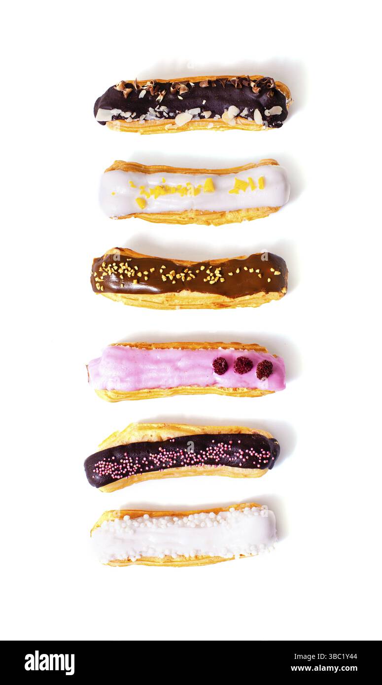 Top view of eclairs with different fillings and designs. Delicious eclairs arranged in a row up and isolated on a white background Stock Photo