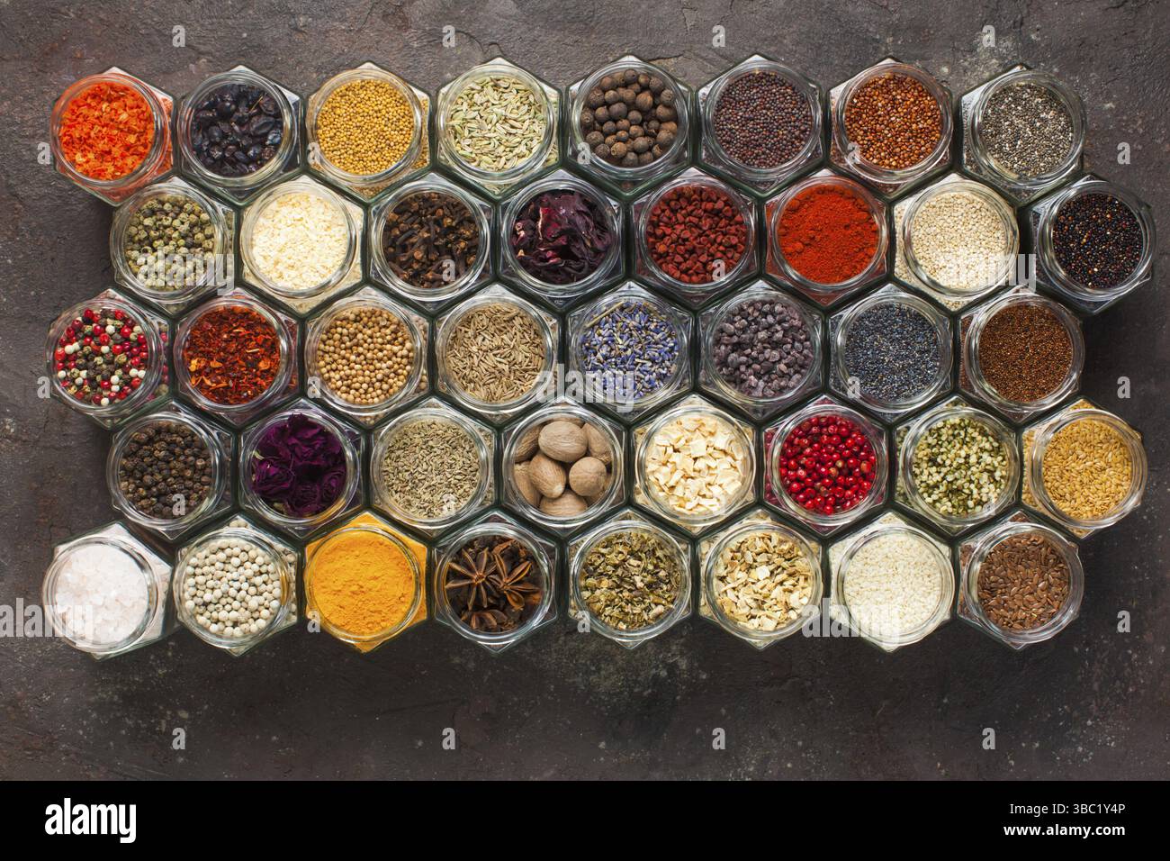 Different kinds of spices and herbs in glass on grey background, top view Stock Photo
