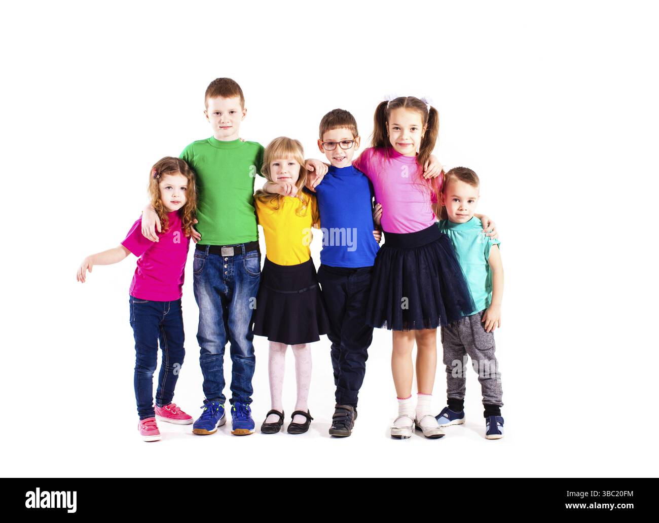The happy kids are standing together embracing each other in colorful ...