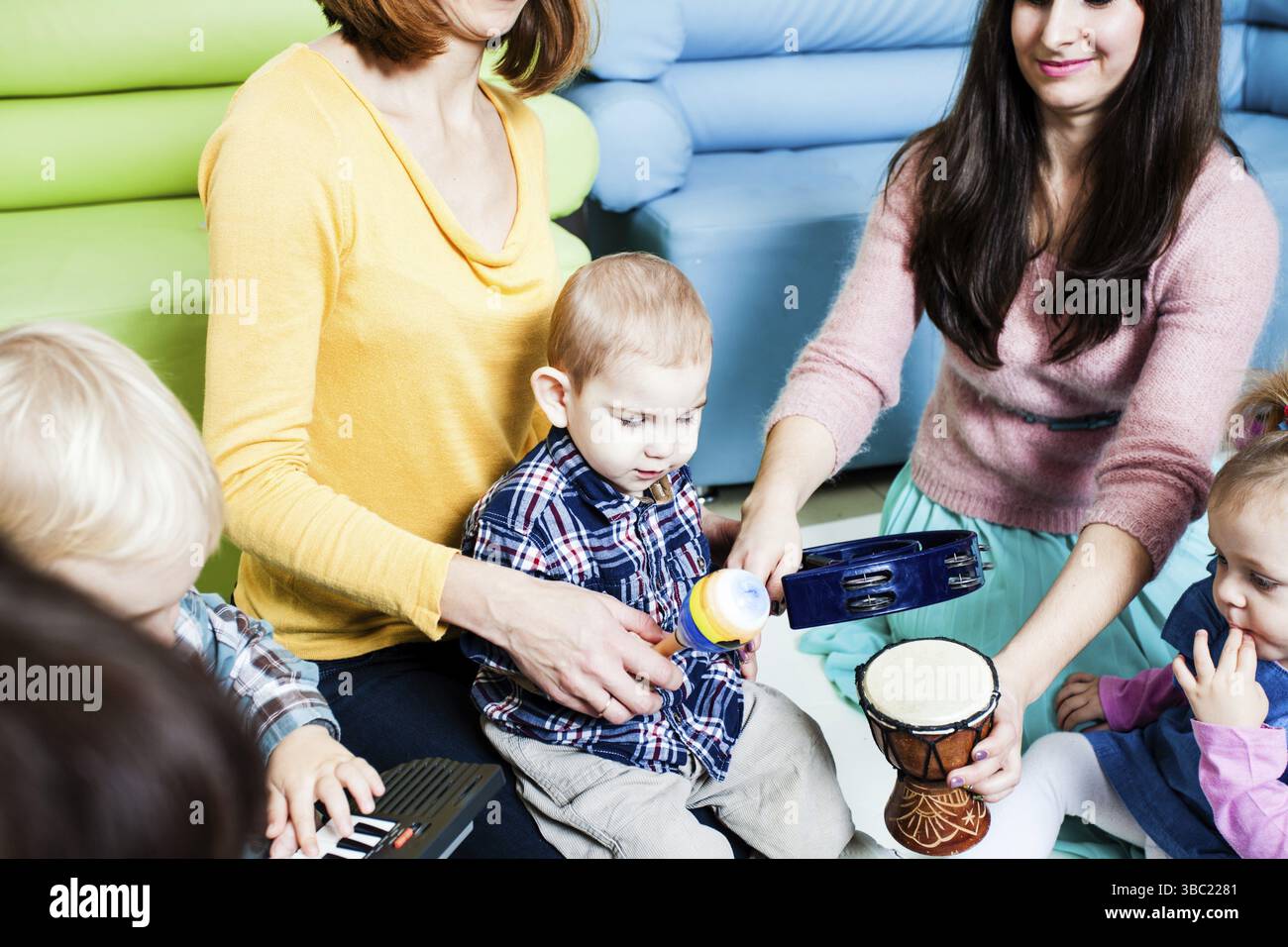 Preschoolers Using Instruments Moms with children at the music lesson in the kindergarten ...