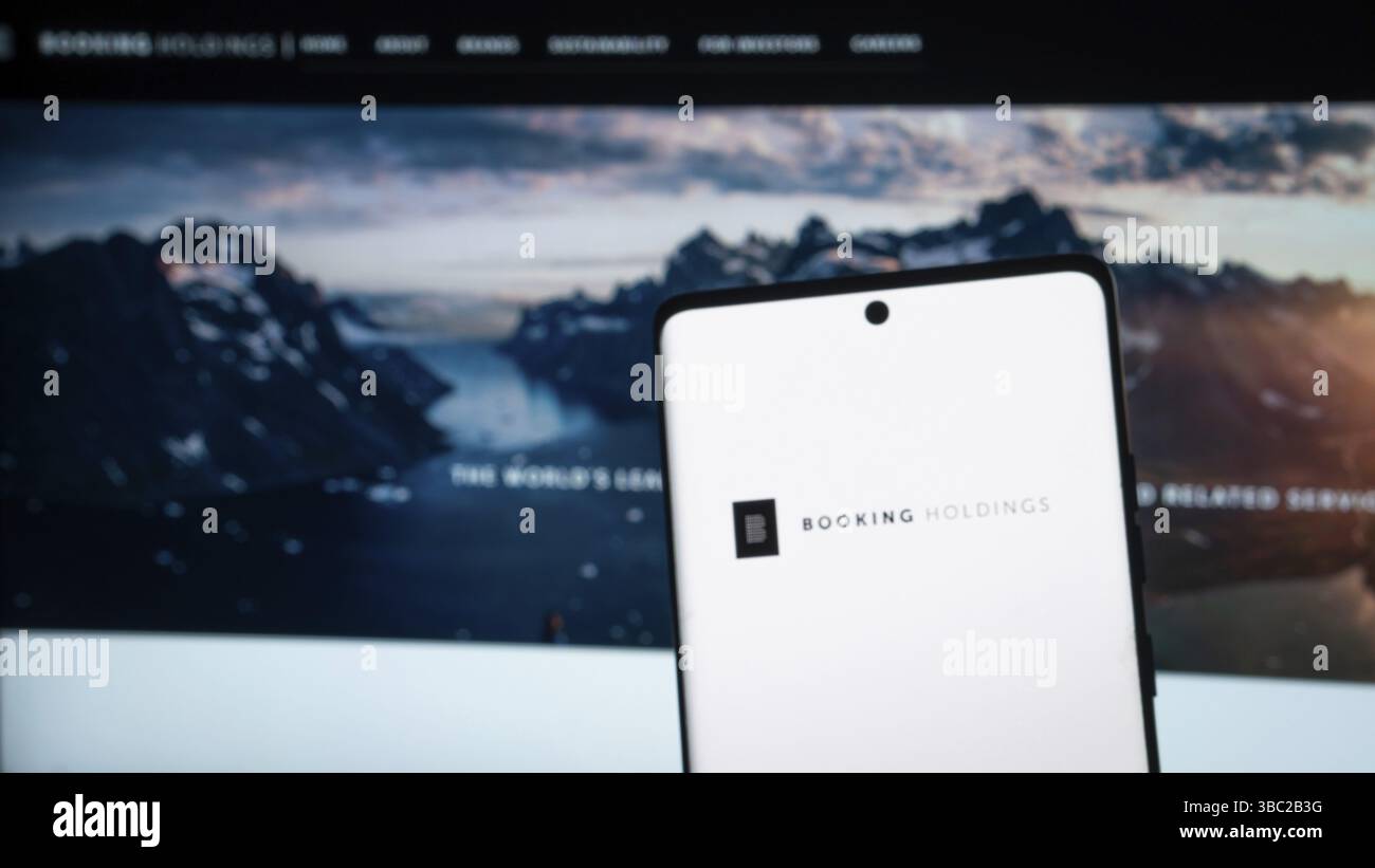 Booking Holdings brand is shown on a phone using the logo Stock Photo