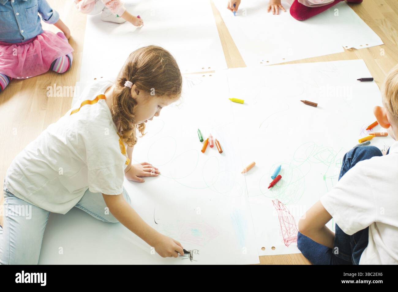 Children Of Different Age Drawing With Crayons On A Large Sheets Of Children of different age drawing with crayons on a large sheets of