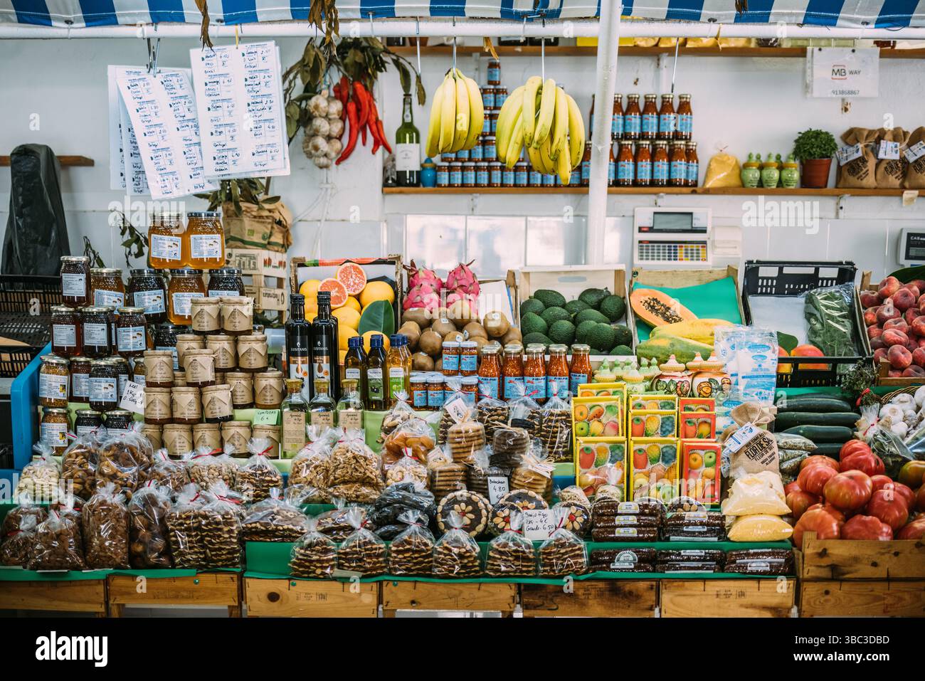 A colorful market stall brimming with fresh fruits, vegetables, and artisanal products in Algarve, Portugal Stock Photo