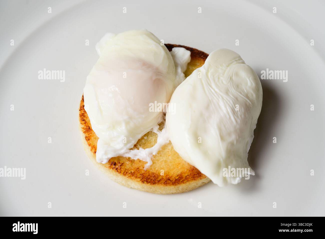 Two Poached Eggs on Toast on a White Plate Stock Photo