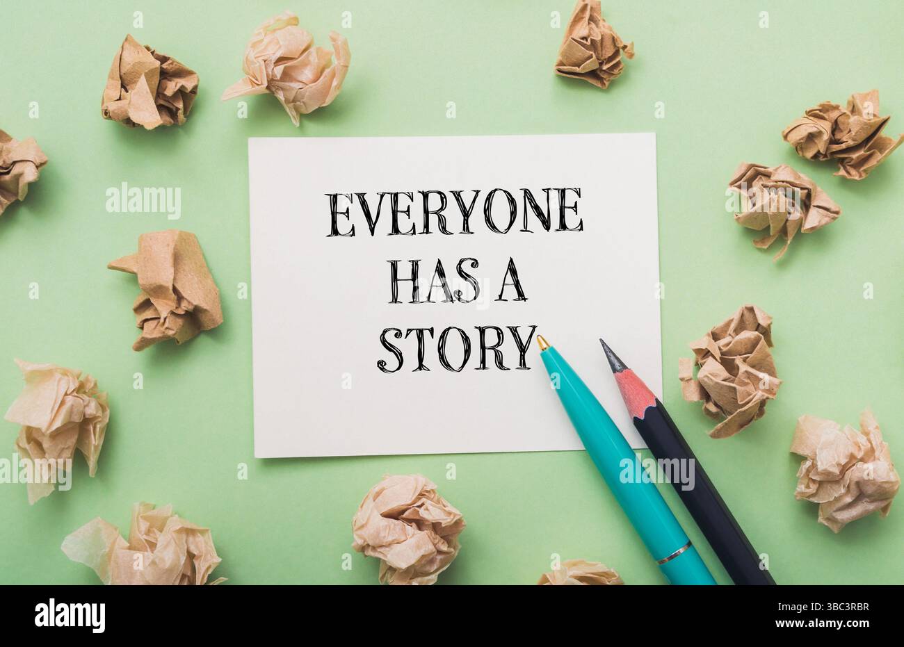 Piece of paper with the words everyone has a story written on it. There are also two pens on the paper Stock Photo