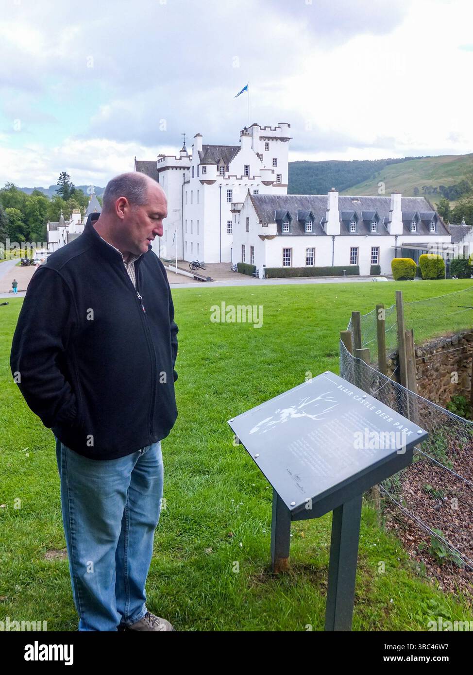 A tourist reads an informational sign at Blair Castle in Pitlochry, Perthshire, Scotland, UK. Stock Photo