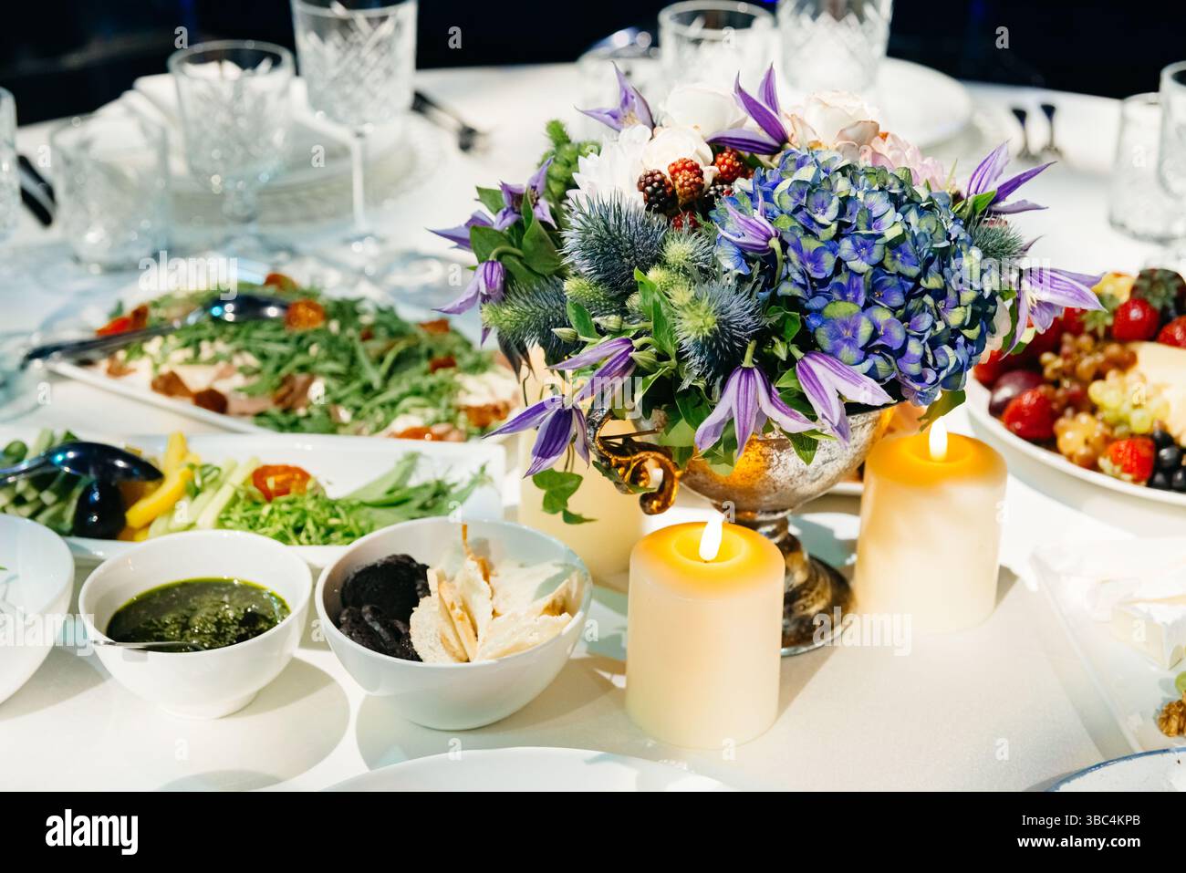elegant-banquet-table-setup-with-a-vibrant-floral-arrangement-candles