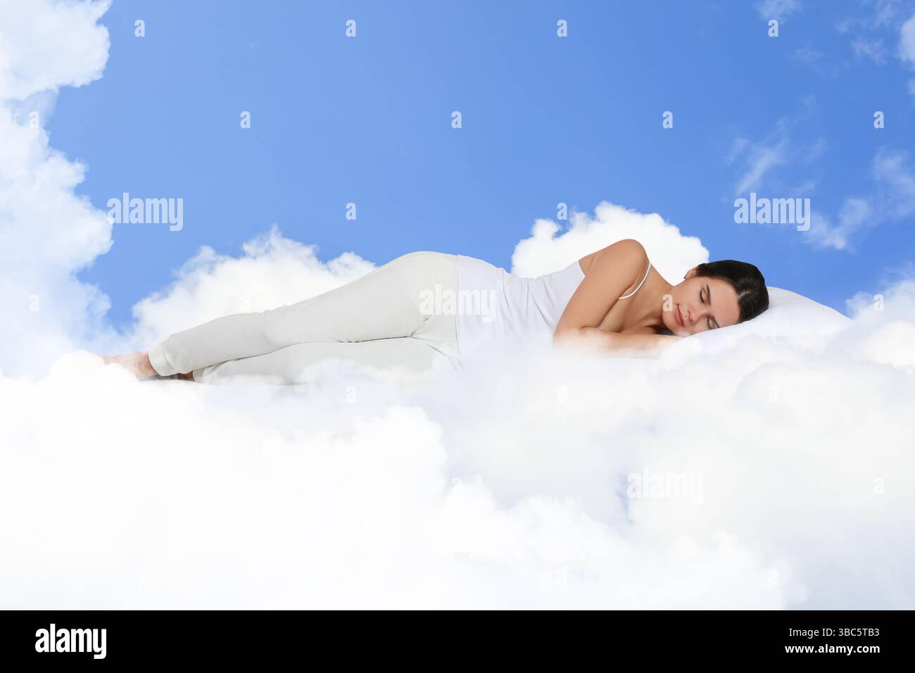 Woman sleeping on fluffy cloud in blue sky. Bedtime Stock Photo - Alamy