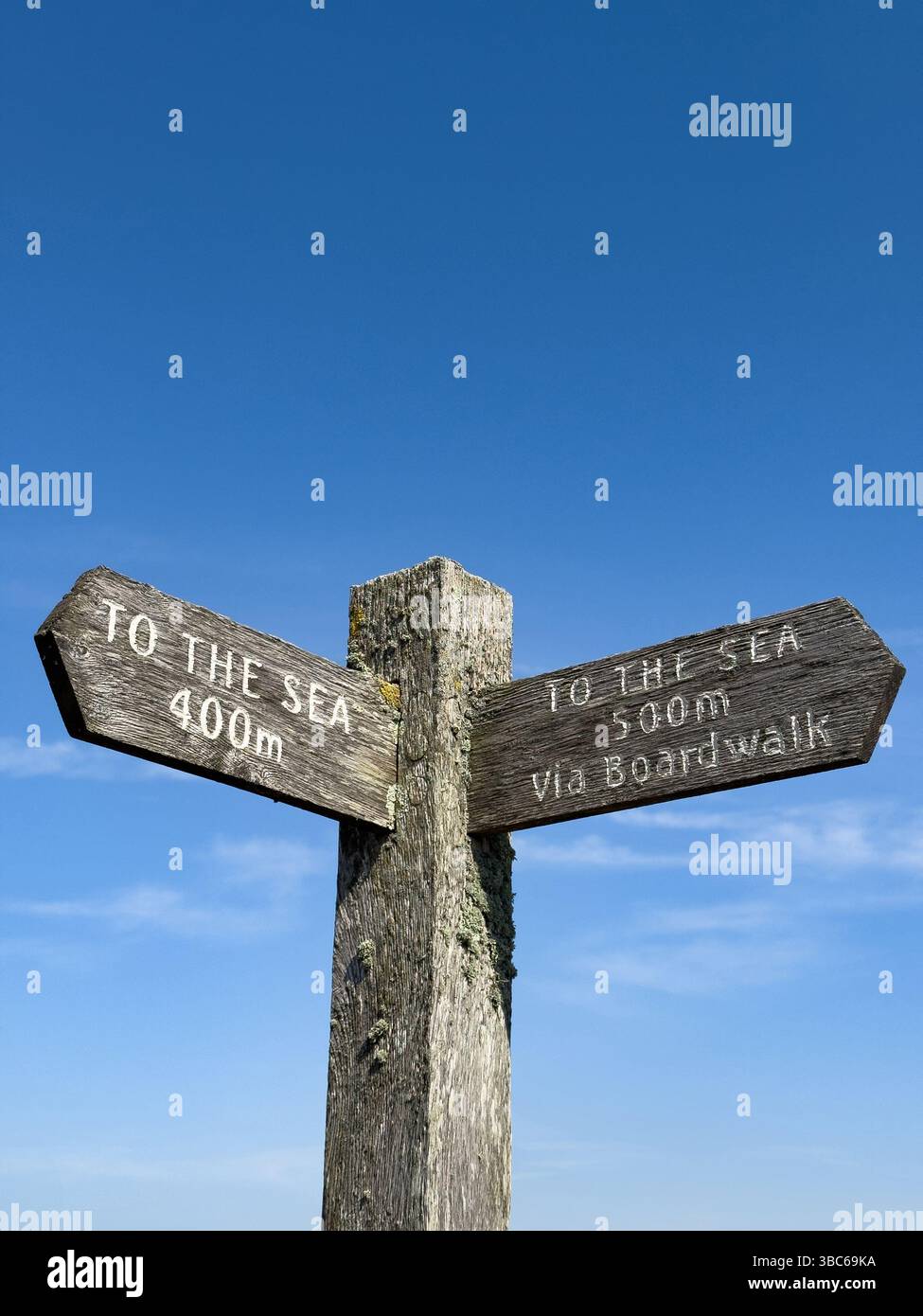 A wooden sign post To the Sea with a blue sky background - Smartphone Captured Stock Image