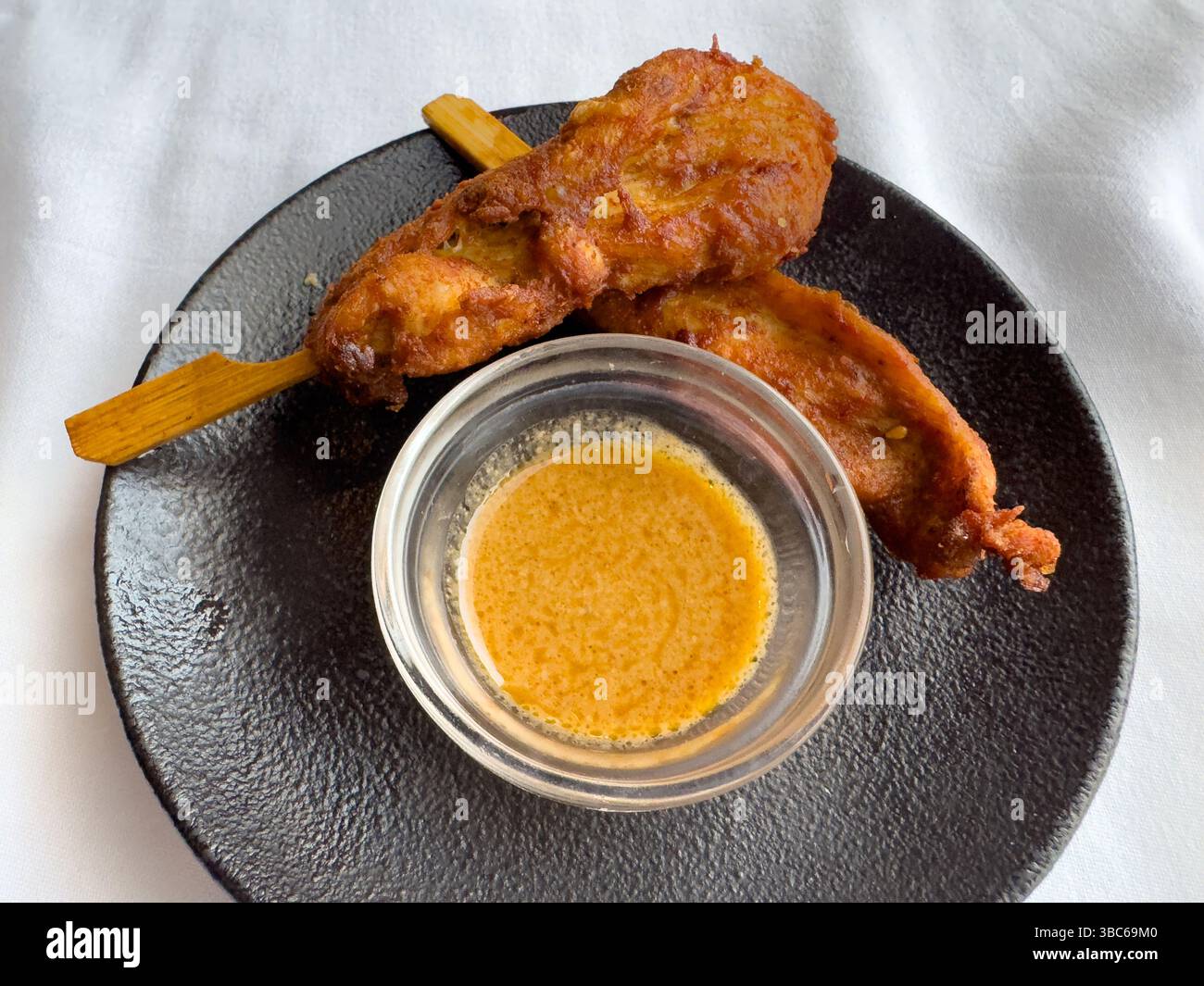 Two chicken satay skewers with peanut sauce - Smartphone Captured Stock Image