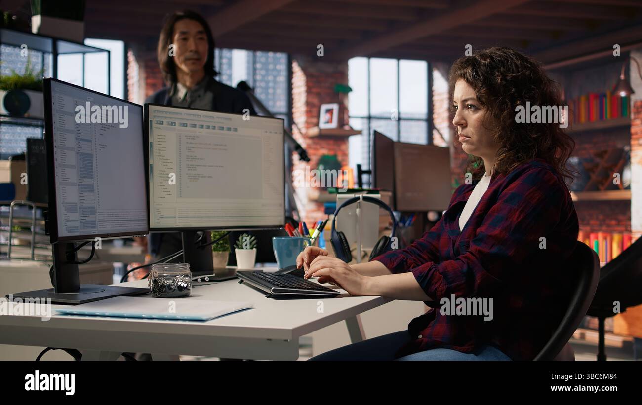 Startup engineer conducting detailed code review to fix bugs, identifying potential performance and technical issues with company software. IT worker debugging and optimizing code, camera A Stock Photo