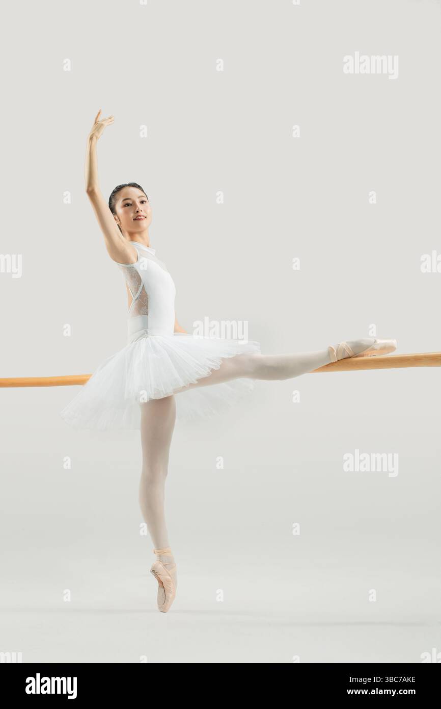 a ballet dancer practicing at the barre​ Stock Photo