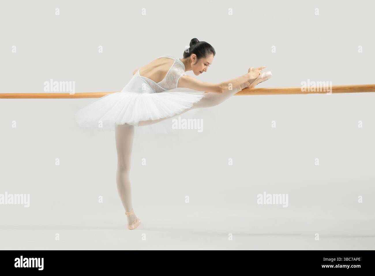a ballet dancer practicing at the barre​ Stock Photo
