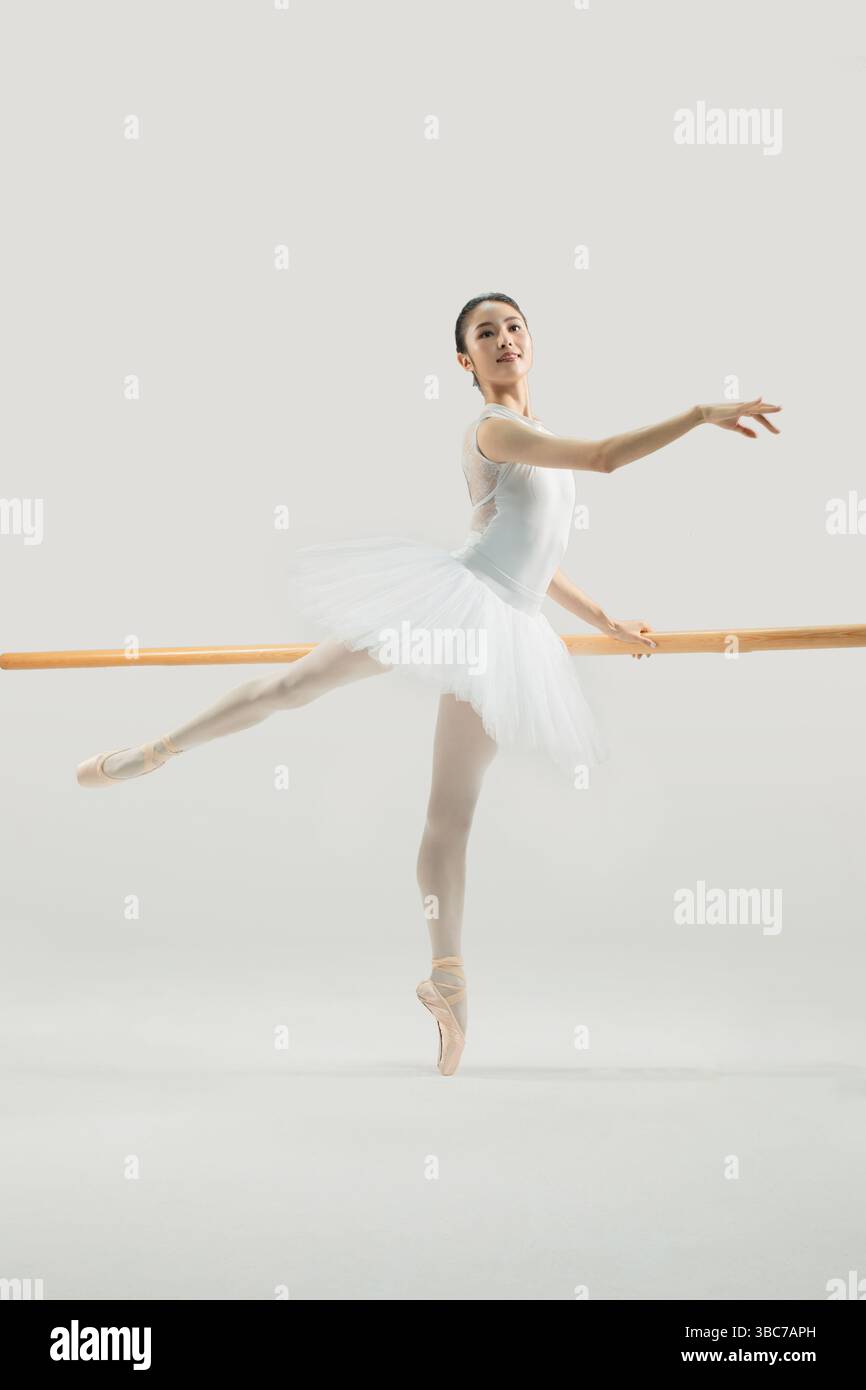 a ballet dancer practicing at the barre​ Stock Photo