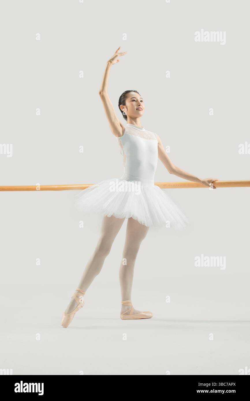 a ballet dancer practicing at the barre​ Stock Photo