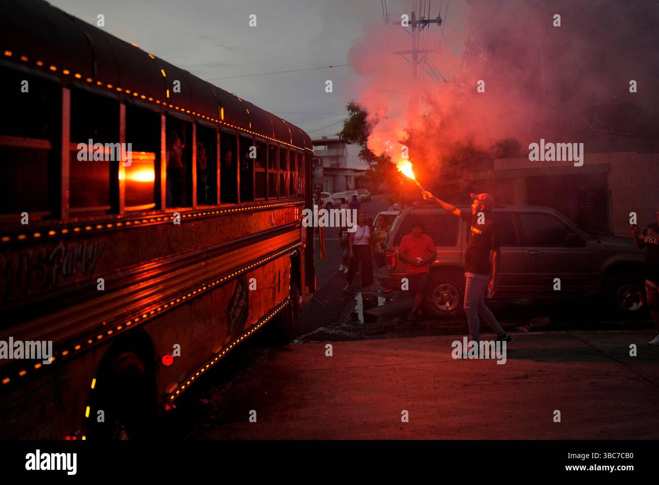 A man illuminates with flare a Red Devil party bus in Panama City ...