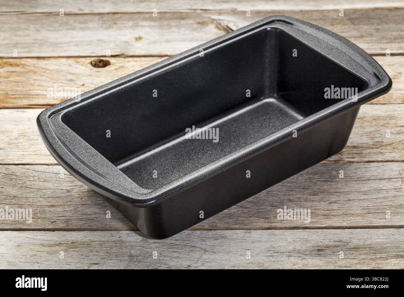 Nonstick metal baking loaf pan on a wooden rustic table Stock Photo
