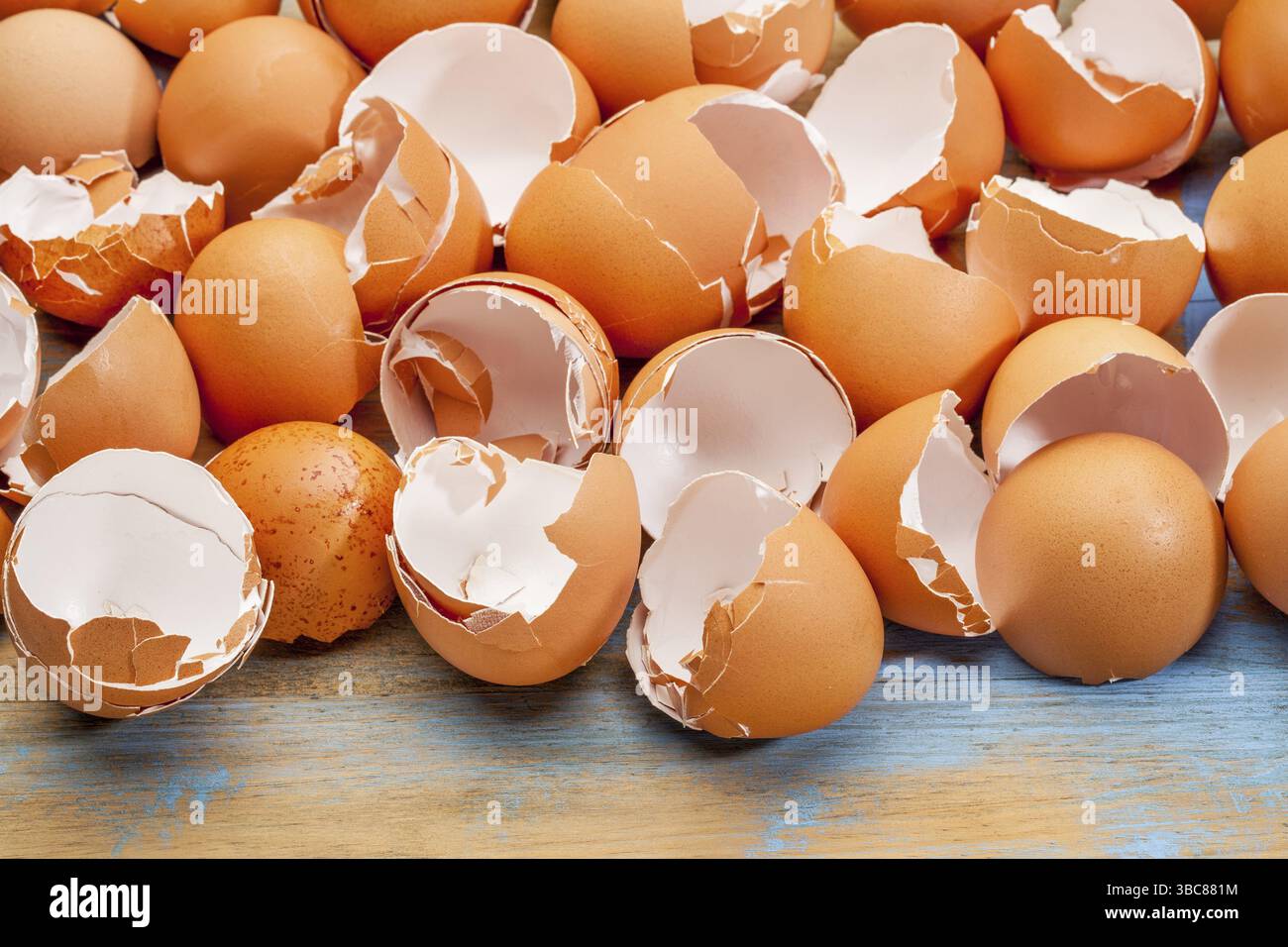 Empty, broken, brown eggshells against wooden background Stock Photo