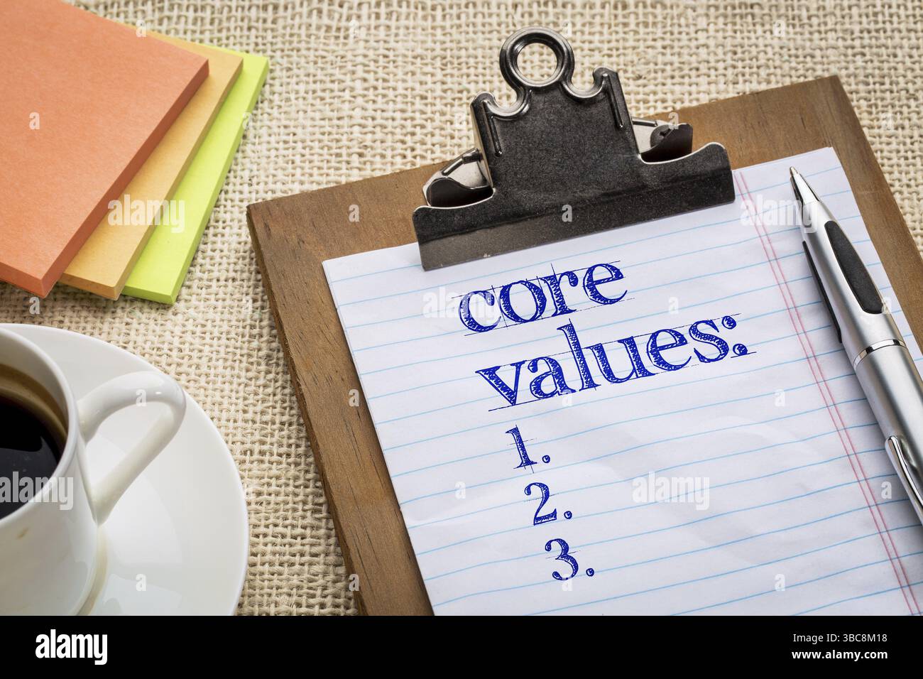 Core values list on clipboard with a pen, coffee and sticky notes ...