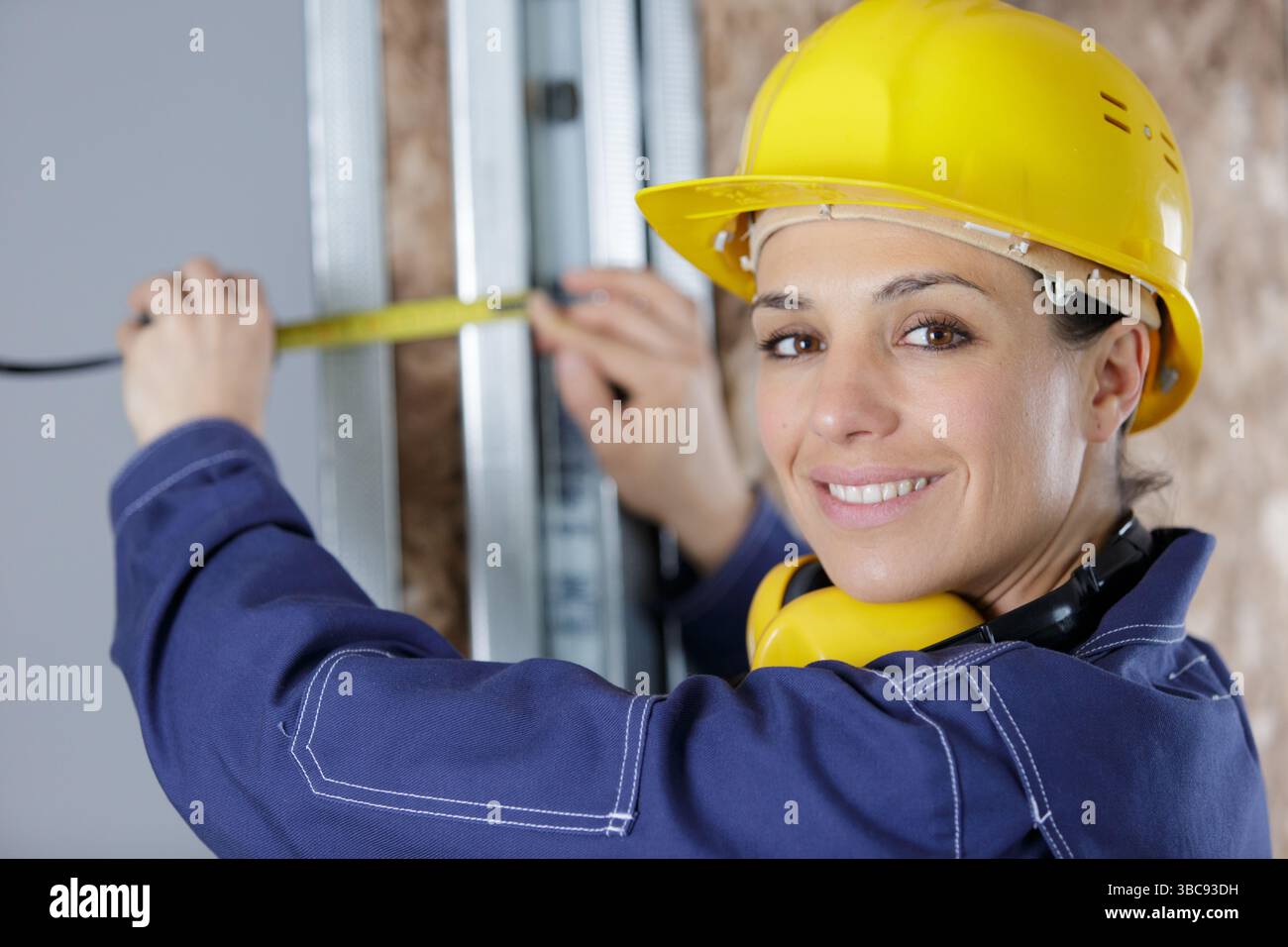 female builder using tape measure Stock Photo