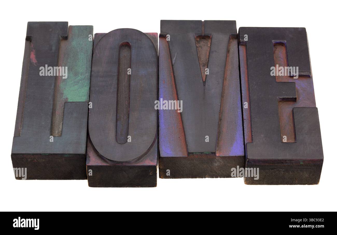 Love word in antique wooden letterpress printing blocks, stained by color inks, isolated on white Stock Photo