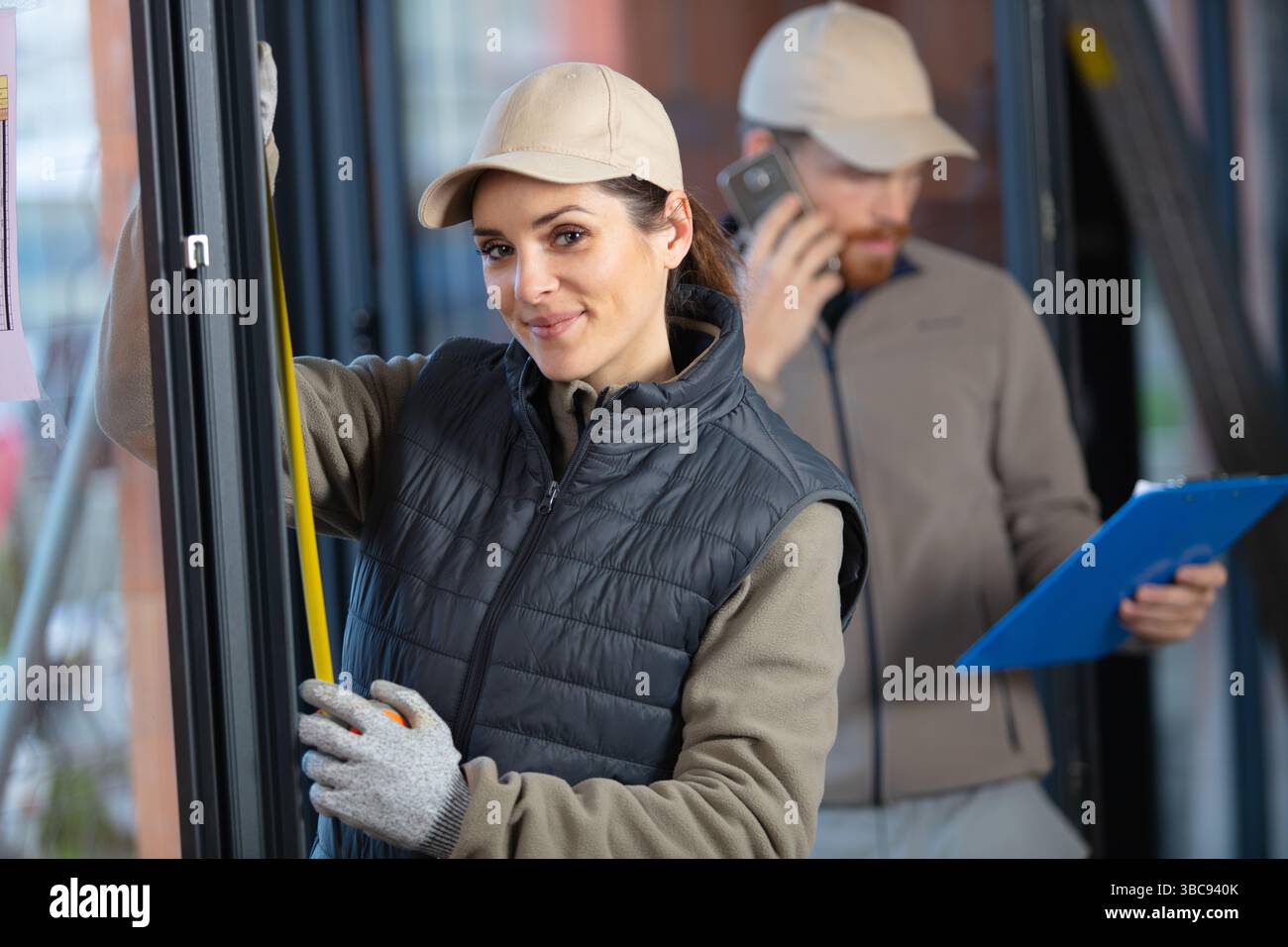 female construction worker using measuring tape Stock Photo