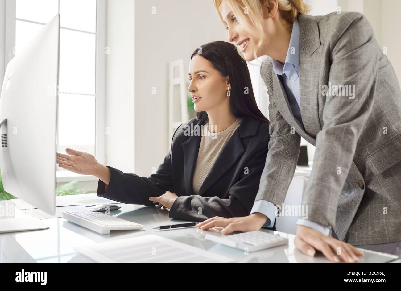 Women Colleagues Using Computer In Office Meeting Stock Photo