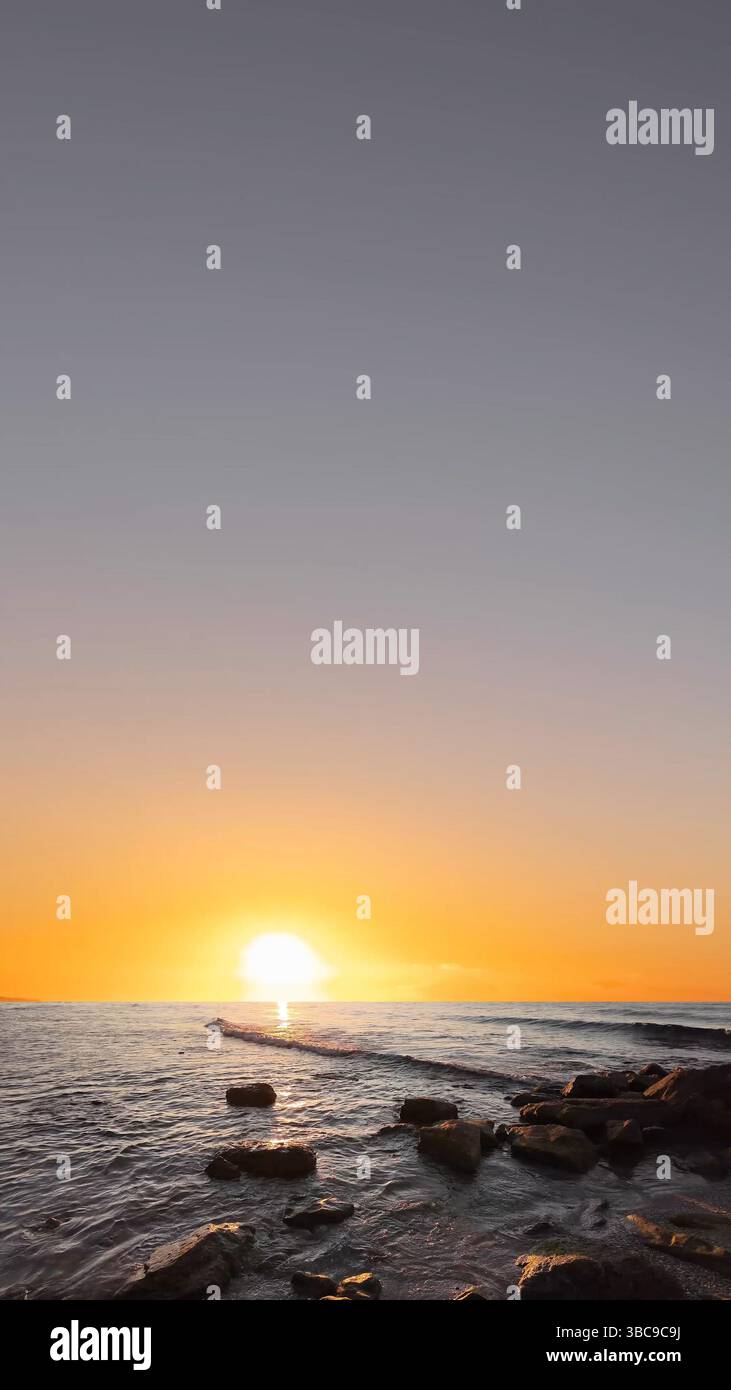 Sea Fade In Sunrise over the sea with gentle waves and fading stars in a peaceful ...