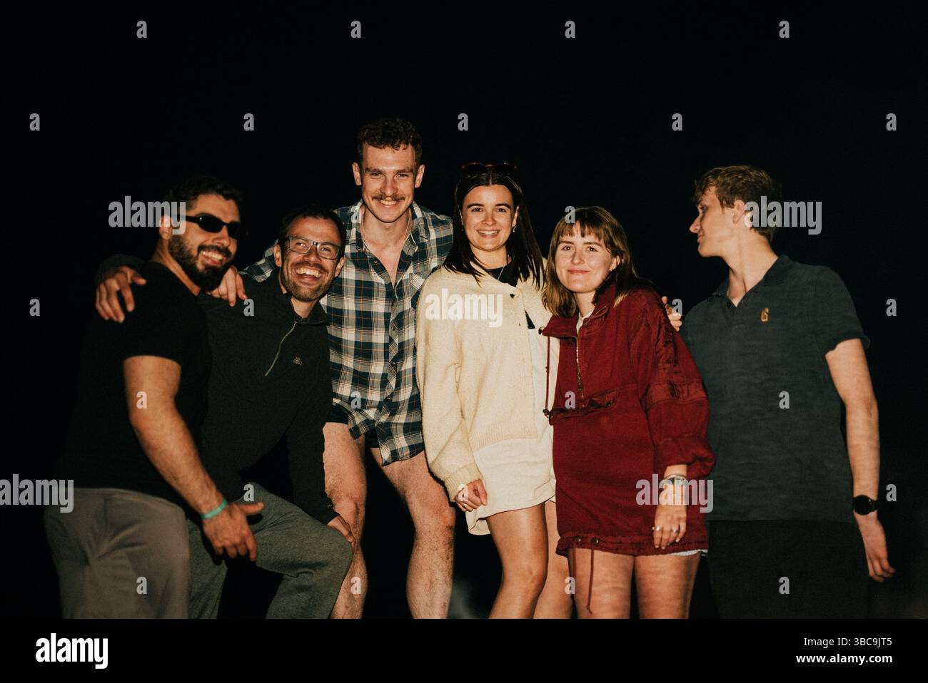 A group of people are posing for a picture, with one woman wearing a ...