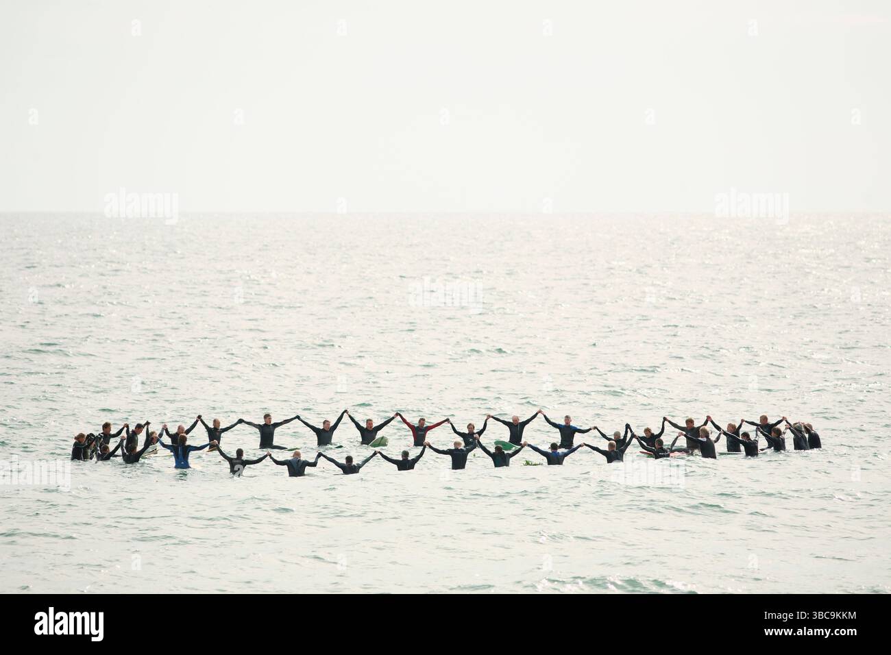 Surfers perform a memorial service paddle-out at Wrightsville Beach ...