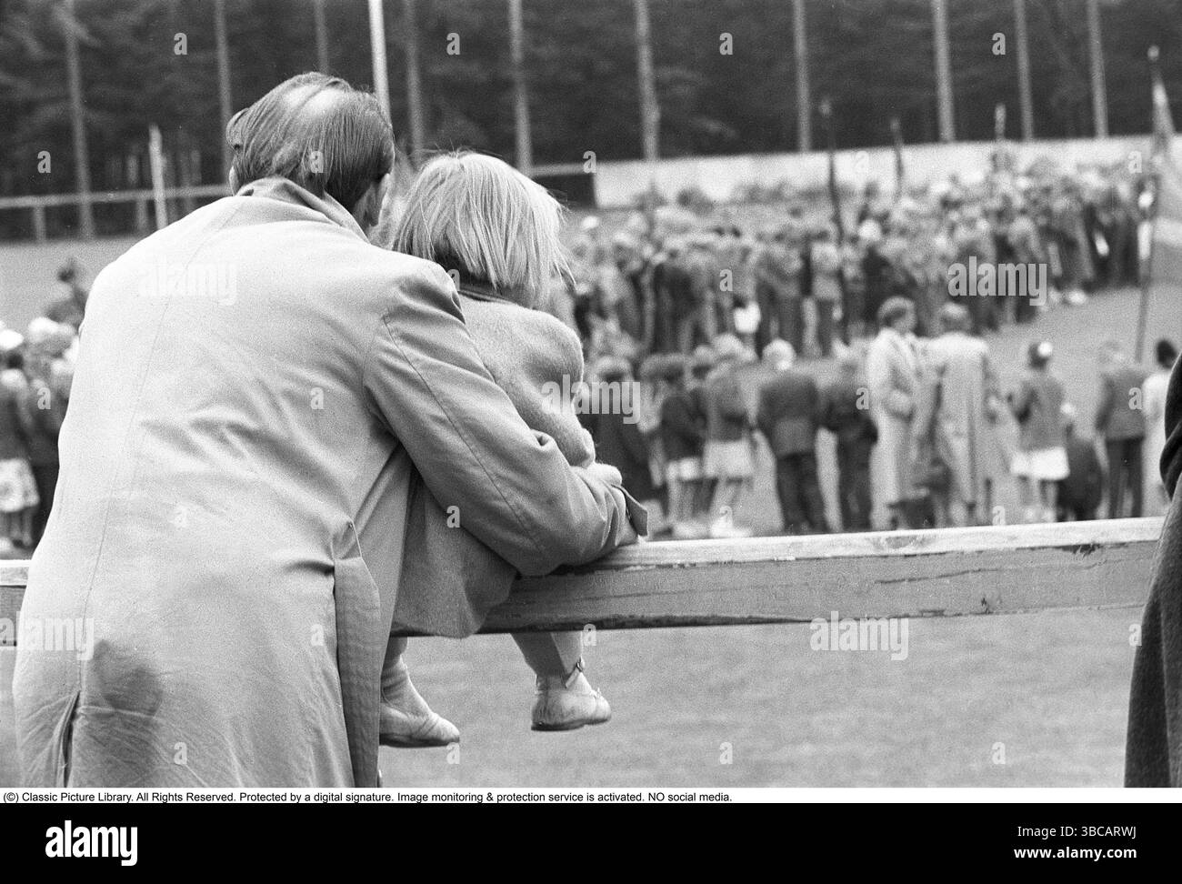 In the 1950s. A father and his daughter are in an audience outside watching and listening to something together. iSweden 1953 Kristoffersson ref 2A-23 Stock Photo