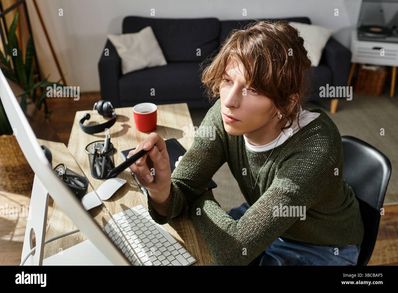 Focused young student working from home, utilizing technology and creativity to study effectively. Stock Photo