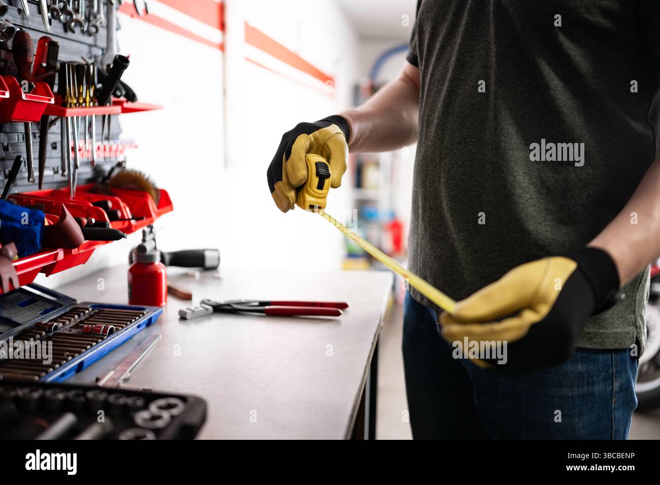 Serviceman Holding A Measuring Tape Behind The Workspace Stock Photo