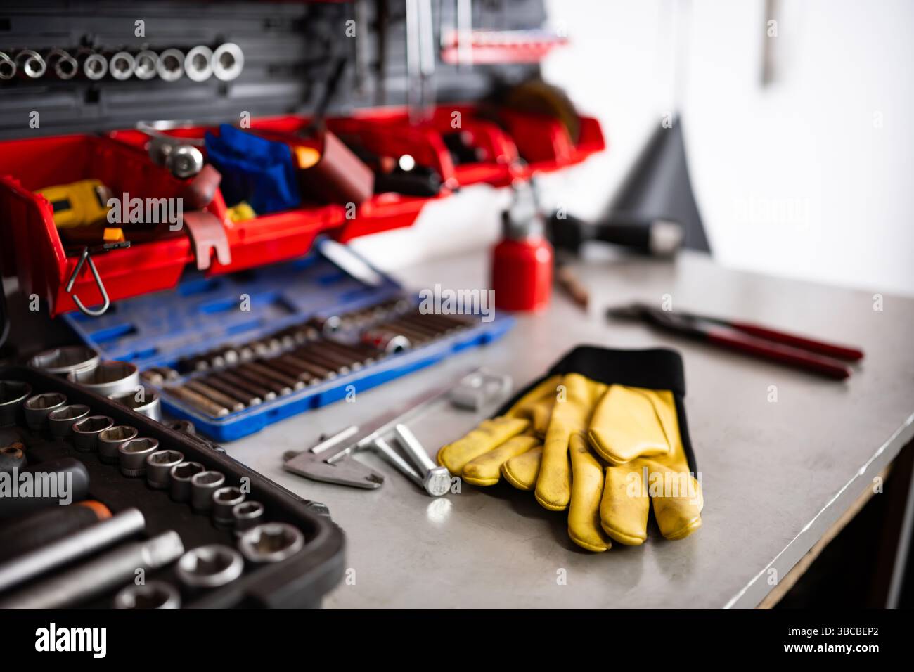 Yellow Protective Gloves On A Mechanic Workbench With Instruments And Tools Stock Photo