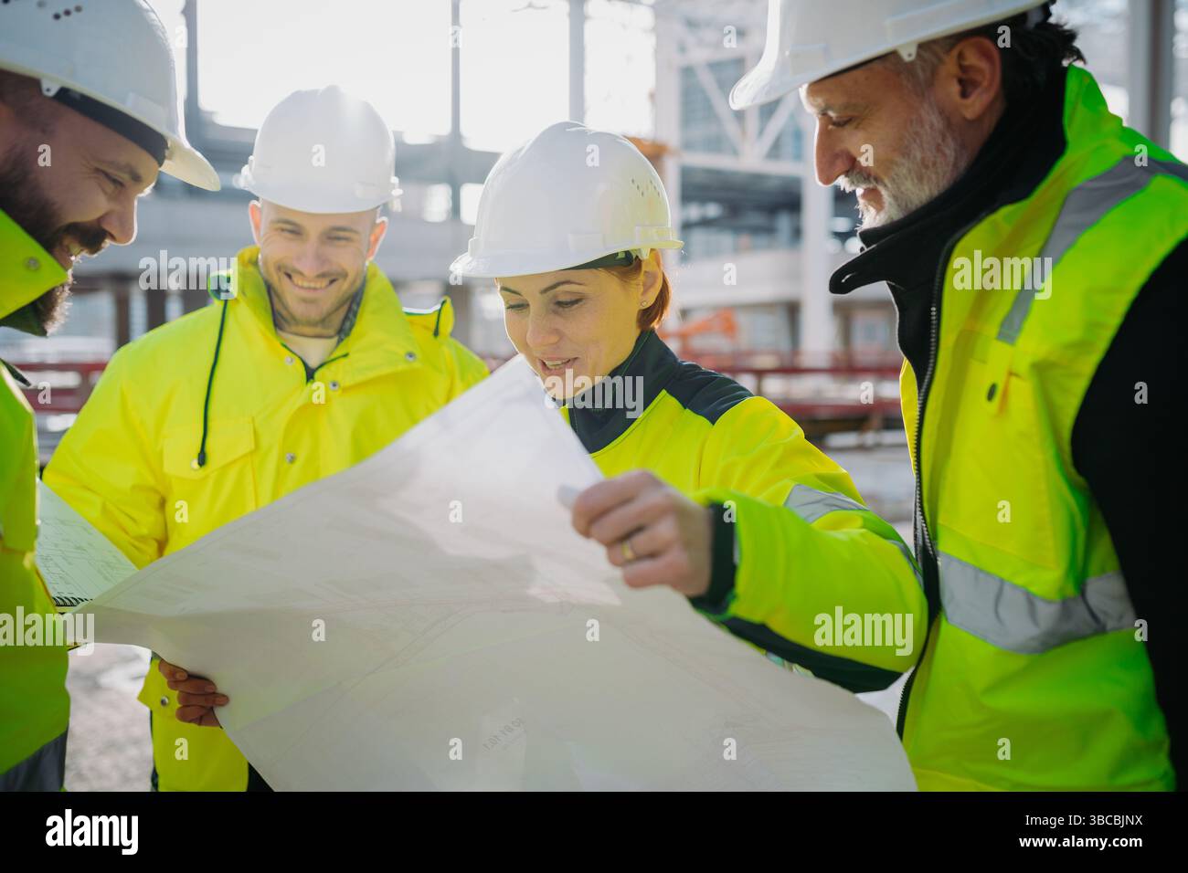 Team of engineers and construction workers inspecting building progress. Stock Photo