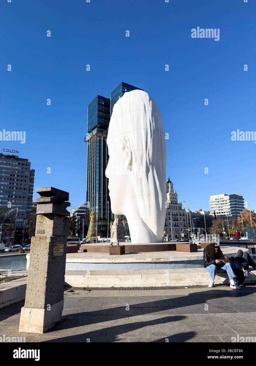Couple with Julia, white marble sculpture by Jaume Plensa in Plaza Colon, Madrid, Spain - Smartphone Captured Stock Image