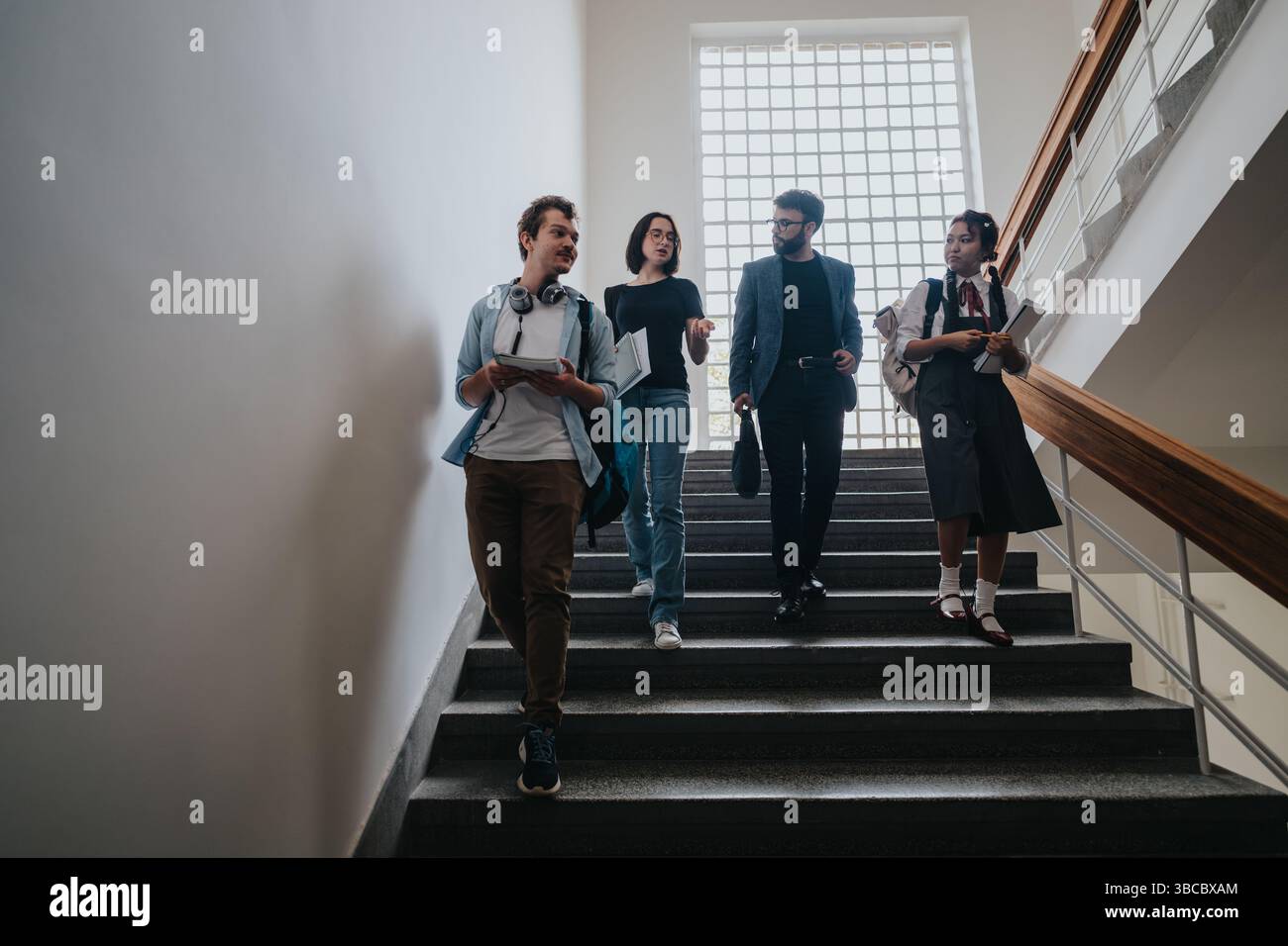 Group of diverse students walking with professor on staircase Stock ...