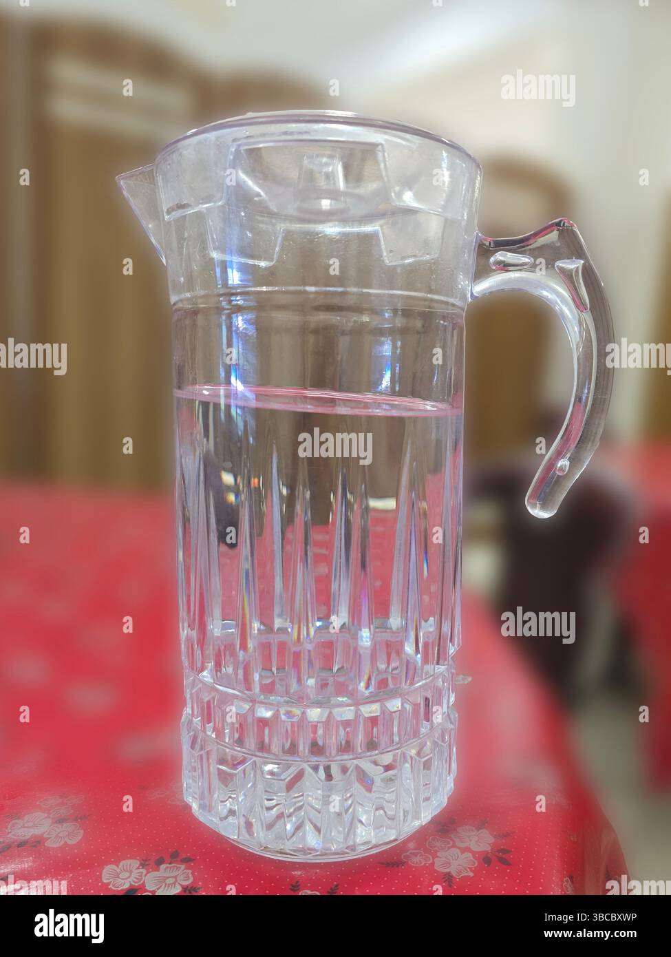 Crystal clear water pitcher on red table - Smartphone Captured Stock Image