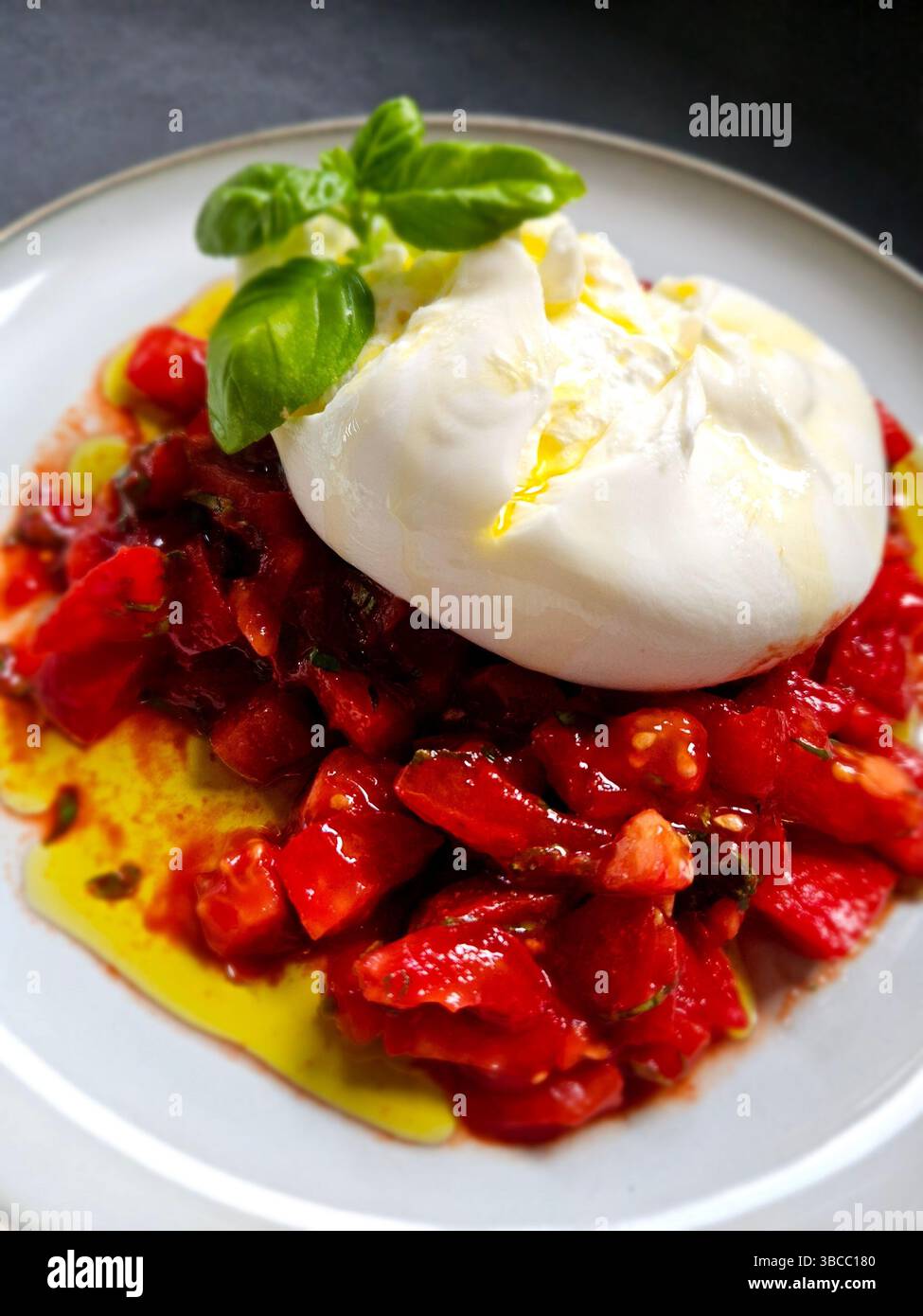 Overhead shot of Italian Caprese salad with creamy burrata, ripe tomatoes, basil, and olive oil. Fresh Mediterranean summer appetizer. - Smartphone Captured Stock Image