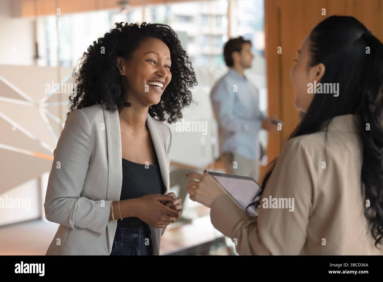 Two positive businesswomen engaged in cheerful conversation Stock Photo ...