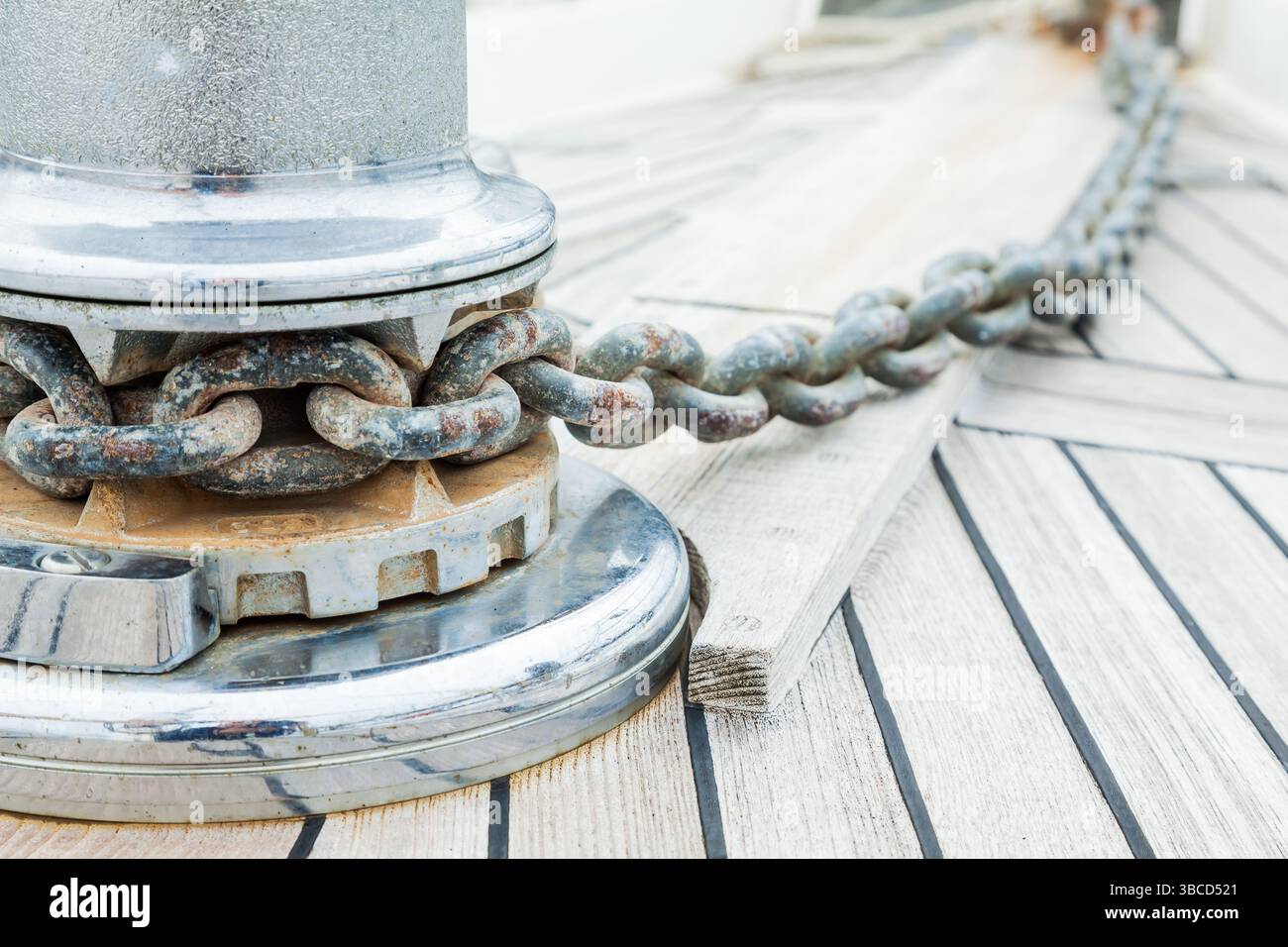 The bow of the yacht with part of the anchor chain and a winch for ...