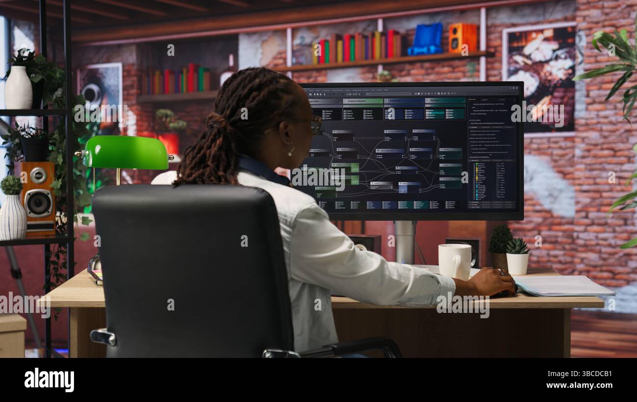 Teleworking programmer using computer for artificial intelligence computing through self learning algorithms. Remote worker working with AI deep neural networks on desktop PC, camera B Stock Photo