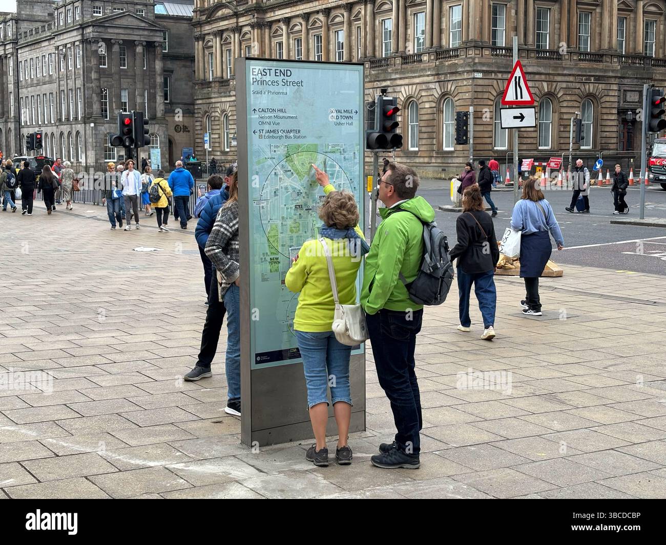 Visitors at information board with city map and attractions on Princes Street East End, Edinburgh Scotland - Smartphone Captured Stock Image